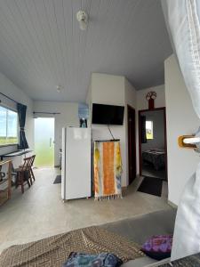 a living room with a refrigerator and a tv at Cantinho da Rasa in Cabo Frio