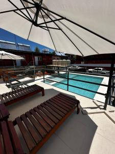a swimming pool with two benches and an umbrella at La posta del vasco in Tanti +12 photos