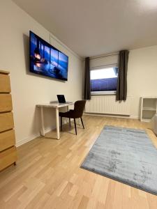 ハノーファーにあるZentrumsnahe Wohnung, Anviolhomesのリビングルーム(デスク、壁掛けテレビ付)