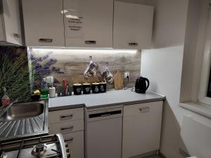 a kitchen with white cabinets and a counter top at Amelia1 in Toruń