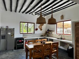 a kitchen with a wooden table and some chairs at Aloe House in Matemwe