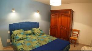 ein Schlafzimmer mit einem Bett und einem Holzschrank in der Unterkunft Aux rives du lac in Villefranche-de-Panat