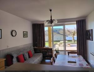 ein Wohnzimmer mit Sofa und Tisch in der Unterkunft Aux rives du lac in Villefranche-de-Panat