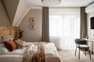 ein Schlafzimmer mit einem Bett, einem Stuhl und einem Fenster in der Unterkunft Willa Amicus in Zakopane