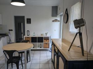 a kitchen with a table and a camera on a tripod at Appartement dans haras in Saint-André-le-Puy