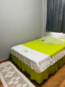 un lit dans une chambre avec un matelas vert et blanc dans l'établissement Cantinho Oliveiras, à Cabo Frio 13 autres photos