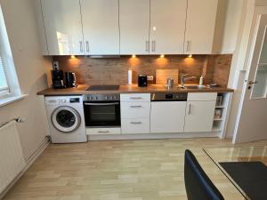 a kitchen with white cabinets and a sink and a dishwasher at Zentrumsnahe Wohnung, Anviolhomes in Hannover