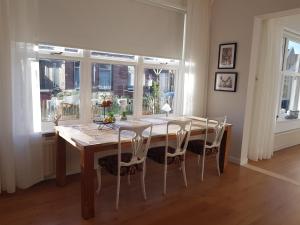 a dining room with a wooden table and chairs at Onder de Beukenboom in Nieuwe Pekela
