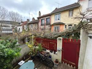 une maison avec une clôture rouge et un vélo sur un balcon dans l'établissement Villa Ribot, à Paris