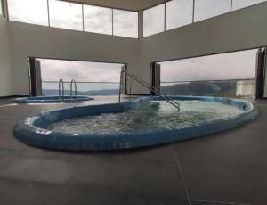 a circular pool of water in a building with windows at Palas Horizon Home B-7-11 in Brinchang