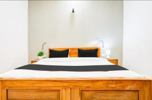 a bedroom with a large bed with a wooden dresser at The Grand Blue Hotel in Greater Noida