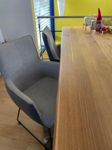 a chair sitting next to a wooden table at RhönLoft - Ferienapartment in Hünfeld