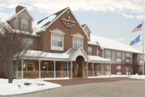 un edificio con un cartel en la parte delantera en Country Inn & Suites by Radisson, Wausau, WI, en Schofield