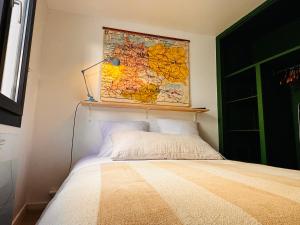 a bedroom with a bed with a map on the wall at Le petit Ré, hypercentre, garage privé, terrasse in Niort