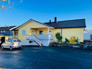 a house with a car parked in a parking lot at Stor enebolig sentralt på Senja in Senja