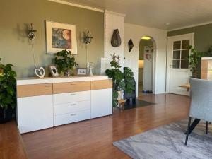 a kitchen with white cabinets and potted plants at Stor enebolig sentralt på Senja in Senja +18 photos