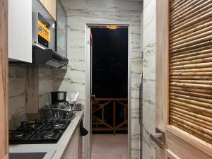 a kitchen with a stove and a door to a wine cellar at Eco Hotel Laguna Beach - Bloque 8 Suite 101 in San Silvestre