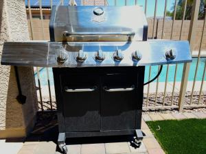 una parrilla de barbacoa sentada en una mesa junto a una valla en 4 Season Spa Heated Dream Pool Jacuzzi Sauna, en Casa Grande