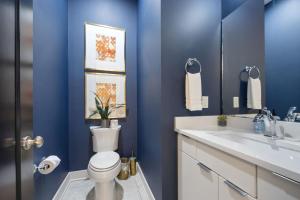 ein blaues Badezimmer mit Toilette und Waschbecken in der Unterkunft LUXURY DOUBLE TOWNHOMES with TWO HUGE SKY ROOFTOPS in Nashville + 173 Fotos
