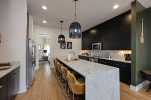 eine Küche mit einer großen Insel mit Barhockern in der Unterkunft LUXURY DOUBLE TOWNHOMES with TWO HUGE SKY ROOFTOPS in Nashville