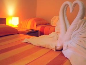 a bedroom with two beds with swan towels on the floor at Amarfia Bed & Breakfast - Your Home In Salerno in Salerno