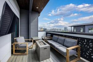 a patio with a couch and chairs on a balcony at Two Townhomes- Rooftop Lounge- Hot Tub- City Views in Nashville