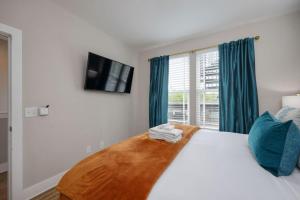 una camera da letto con un letto bianco con cuscini blu e una finestra di Two Townhomes - Hot Tubs and Rooftop Balconies a Nashville Altre 138 foto