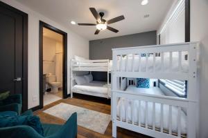 a bedroom with two bunk beds and a ceiling fan at Two Townhomes- Rooftop Lounge- Hot Tub- City Views in Nashville +116 photos