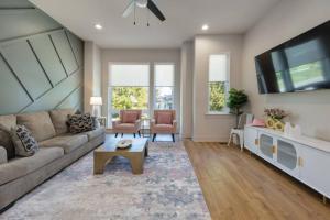 Una sala de estar con un sofá y un televisor. en Cowgirl Up 4BD 4.5BTH Rooftop Views, en Nashville