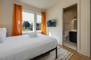 Un dormitorio con una gran cama blanca y un baño. en Cowgirl Up 4BD 4.5BTH Rooftop Views, en Nashville