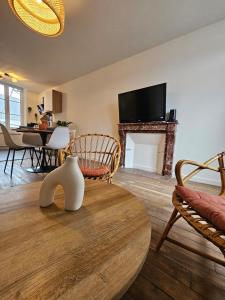 a living room with a table and a fireplace at L'authentique - Appartement 4 in Loudéac