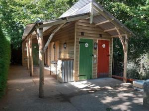 a wooden shed with awning and two doors at Dogwood Cabin in Rye