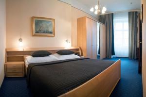 a bedroom with a large bed with two pillows at Hotel Bajazzo in Vienna