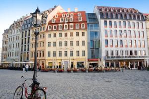 una bicicleta estacionada en una calle frente a los edificios en Aparthotel Altes Dresden, en Dresden