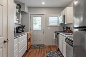 a kitchen with white cabinets and a sink and a door at Sweet Jasper Suite-Summer Getaway in Jasper with Hot Tub in Jasper