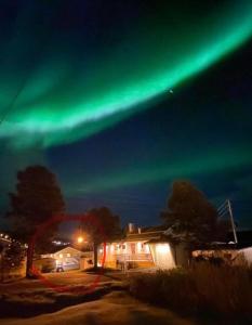 an aurora in the sky over a house at Stor enebolig sentralt på Senja in Senja