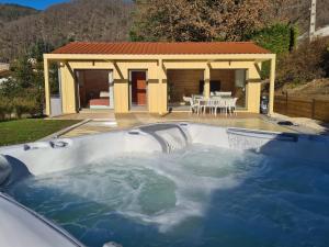 a hot tub in the backyard of a house at Le Cottage des Cerisiers in Saint-Paul-en-Cornillon