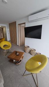 a living room with two yellow chairs and a table at Escape to the Pacific of Panama in San Carlos