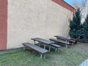 three wooden benches sitting next to a wall at Apartmán Hollého in Žilina +1 photo