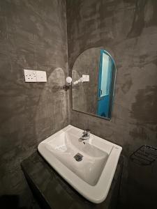 a bathroom with a sink and a mirror at Sri Villa Polwatta in Weligama