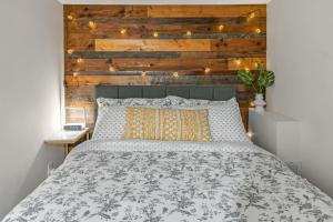 een slaapkamer met een bed met een houten muur bij 2 BR ground-level suite in a bungalow with full kitchen, parking, and 20 mins to Downtown in Toronto