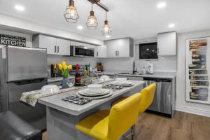 een keuken met een aanrecht en gele stoelen. bij 2 BR ground-level suite in a bungalow with full kitchen, parking, and 20 mins to Downtown in Toronto +16 foto's