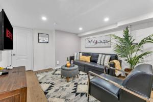 een woonkamer met een bank en een tv bij 2 BR ground-level suite in a bungalow with full kitchen, parking, and 20 mins to Downtown in Toronto