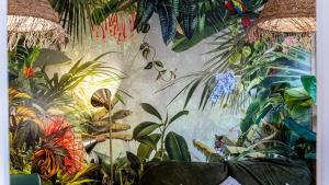 un mur orné d'une fresque murale représentant des plantes. dans l'établissement JunglAppart - Votre Refuge Jungle Proche de la Gare et du Centre-Ville, avec Garage, à Dijon