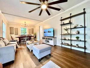 a living room with a couch and a ceiling fan at The Charming Location in Waycross