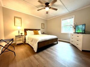 a bedroom with a bed and a ceiling fan at The Charming Location in Waycross