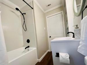 a white bathroom with a sink and a shower at The Charming Location in Waycross +8 photos