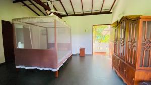 a bedroom with a bed and a dresser at southern grace hotel in Unawatuna