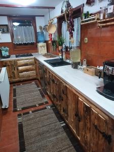 una cucina con armadi in legno e ripiani bianchi di Coliba Padurarului a Porumbacu de Jos
