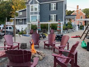 a backyard with chairs and a fire pit in front of a house at Cottage 1-2 -2 Bedroom 1 Bath End Unit with Kitchenette Private Courtyard Pet Friendly fee applies in Wolfeboro